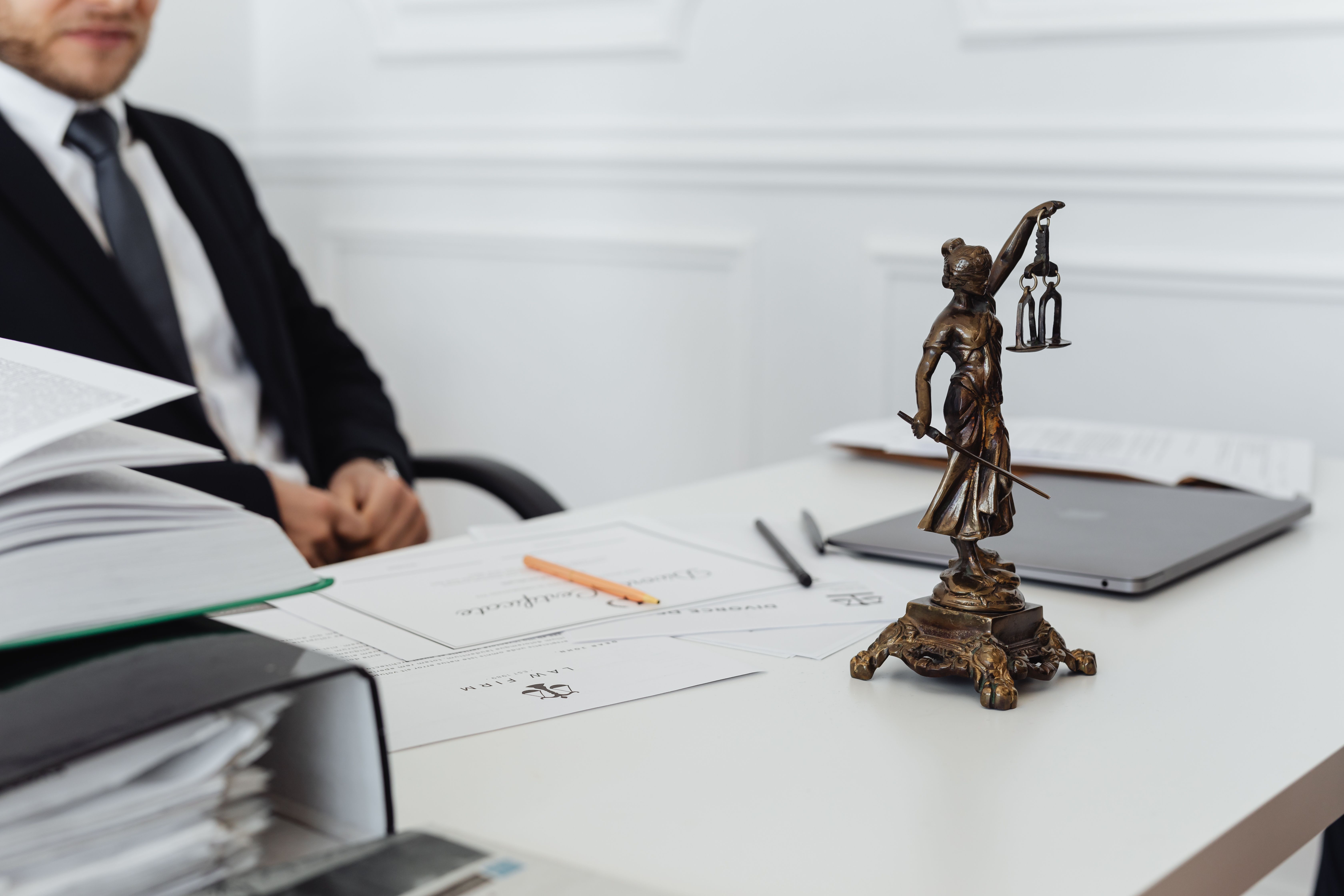 Statuetă a justiției lângă documente contractuale